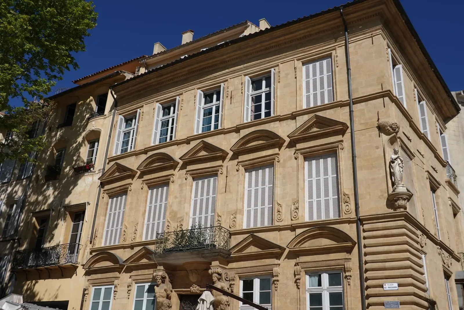 The carved façade of a hôtel particulier under a blue sky