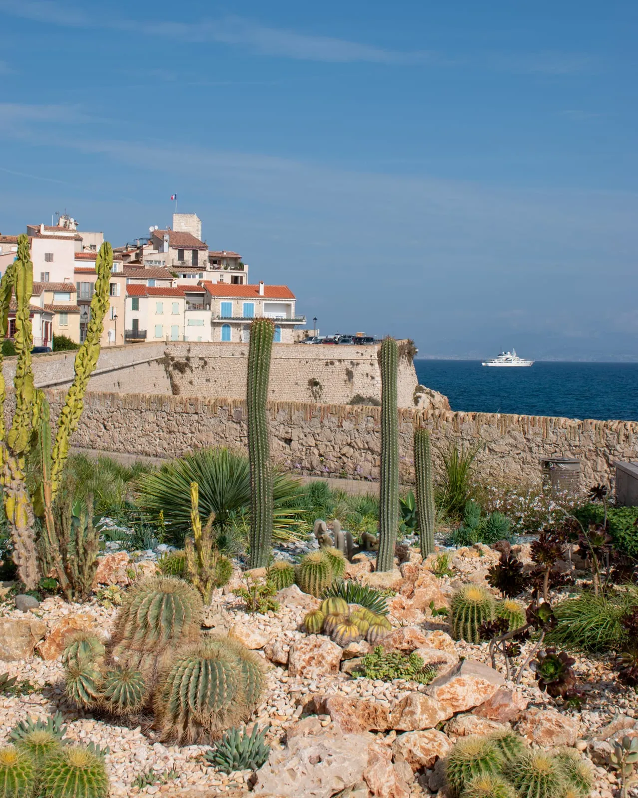 Les remparts de pierre entre les pins et la mer, la vieille ville et son clocher