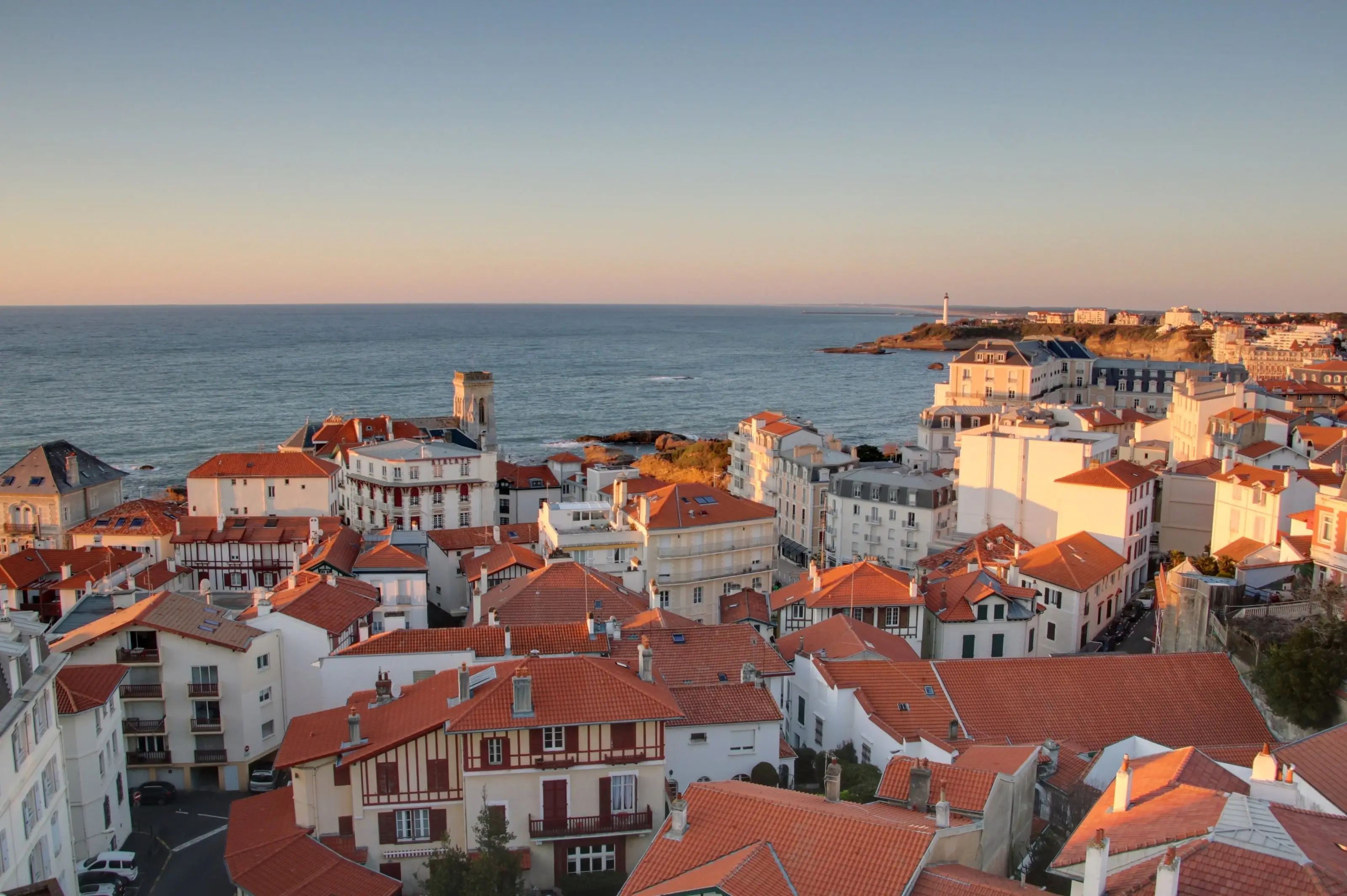 Les toits de Biarritz au couchant, l’océan et le phare au loin