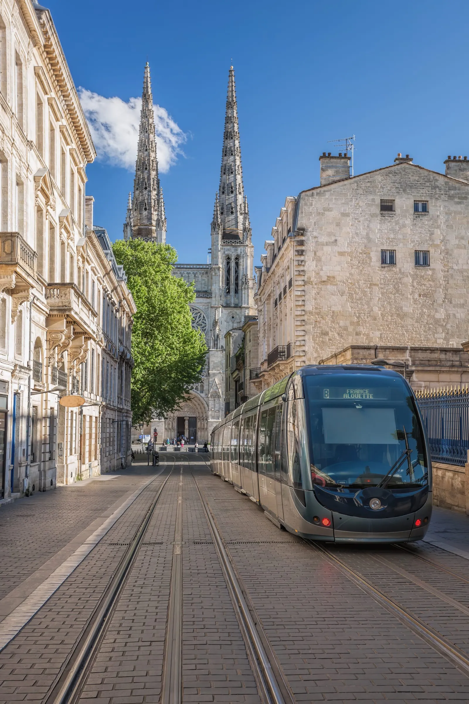 Les flèches de la basilique Saint-Michel au bout d’une rue de tramway, à Bordeaux