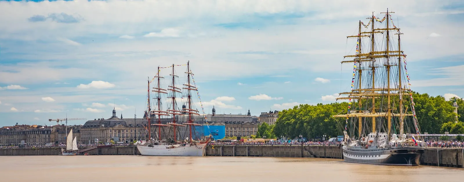 Des grands voiliers à quai sur la Garonne, devant les façades des quais de Bordeaux