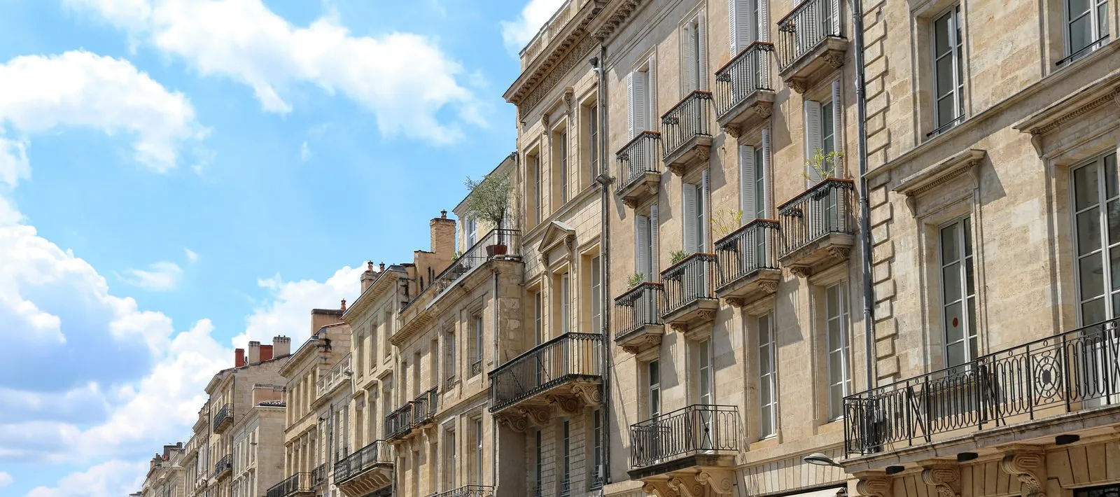 L’alignement des façades de pierre et des balcons en fer forgé, à Bordeaux