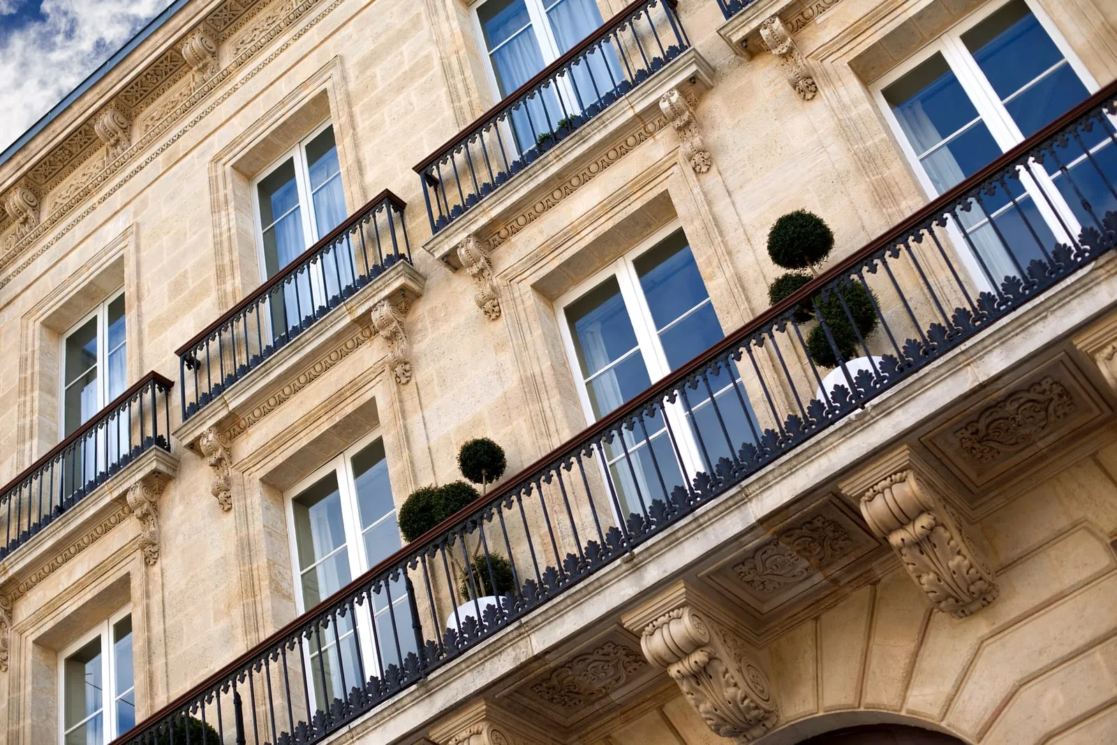Les balcons en fer forgé d’une façade bordelaise, vus d’en bas