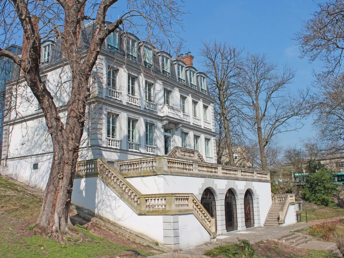 O castelo de l’Étang em Bagnolet, a sua fachada branca e a sua escadaria de pedra entre grandes árvores