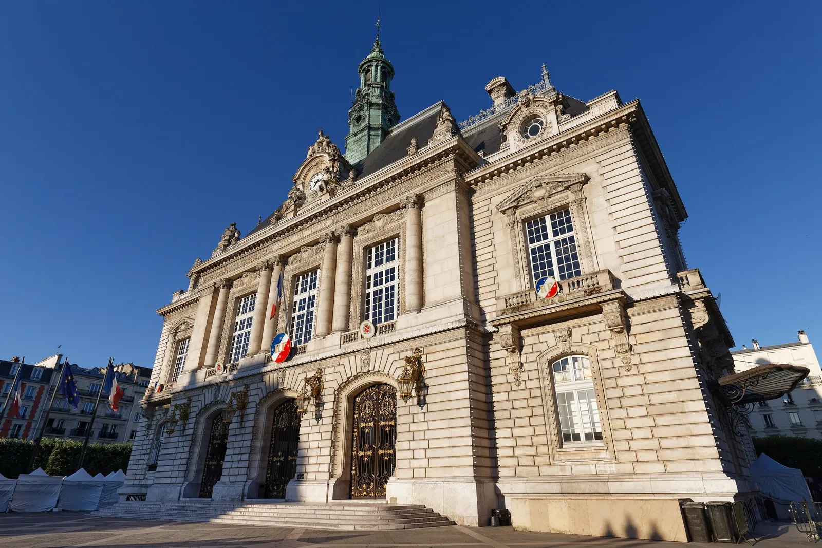 A câmara municipal de Levallois-Perret, a sua fachada de pedra esculpida e o seu campanário sob o céu azul