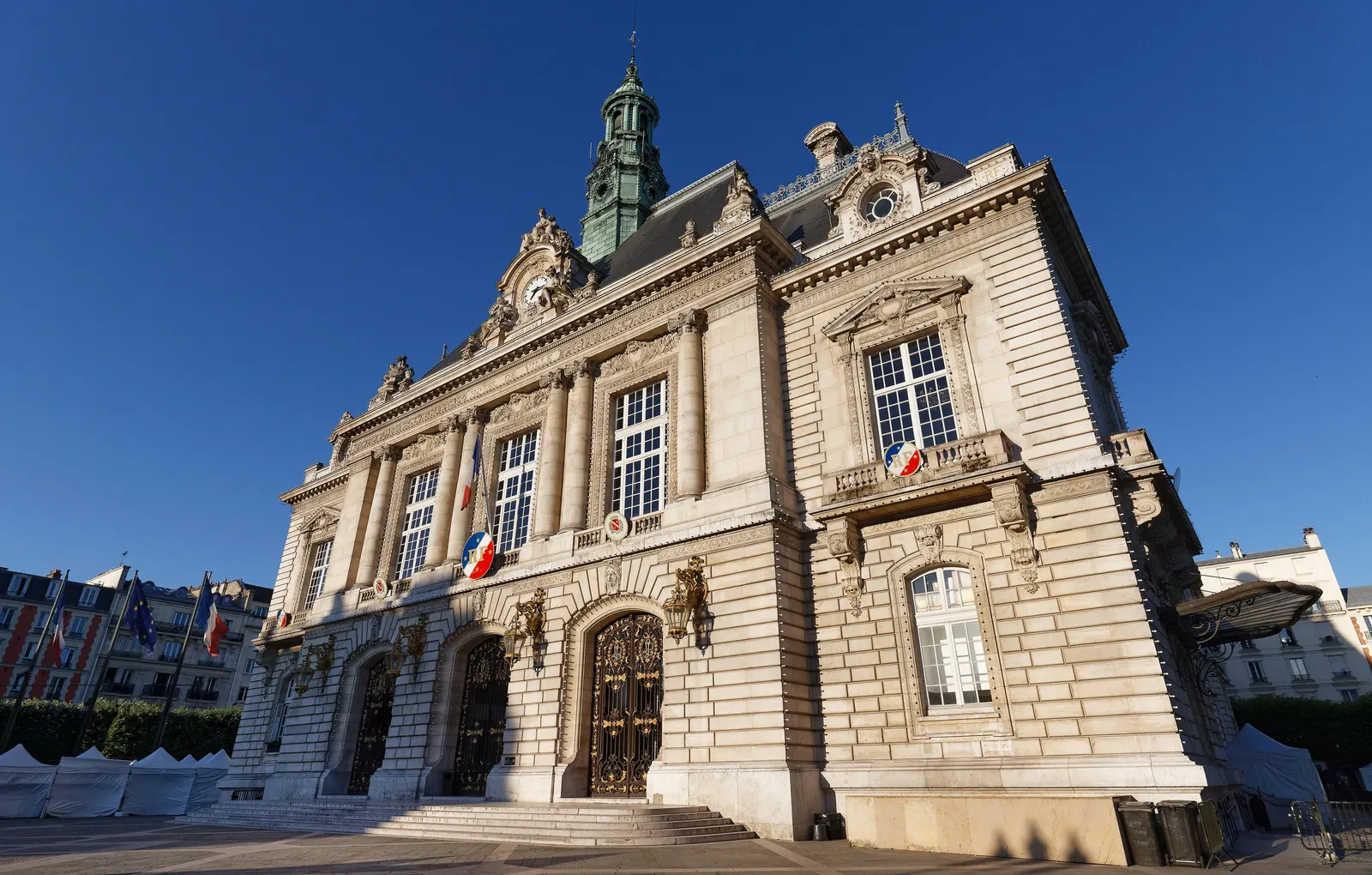 The town hall of Levallois-Perret, its carved stone façade and its bell tower under a blue sky