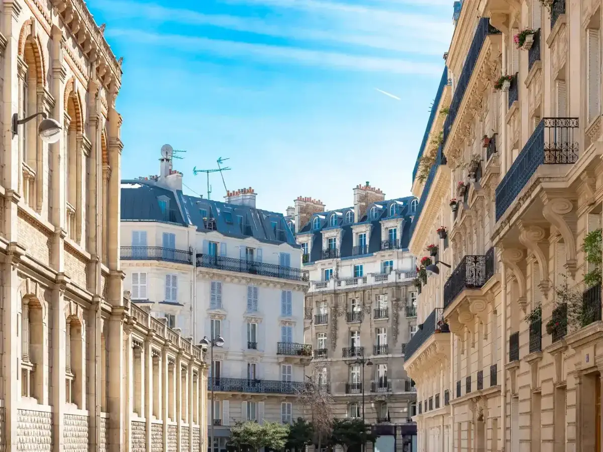 Une rue haussmannienne en perspective, déserte sous un ciel bleu