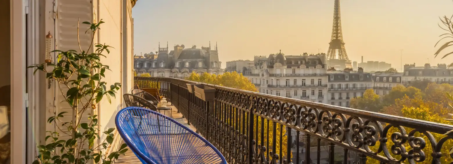 A varanda de um apartamento parisiense e a Torre Eiffel ao fim do dia