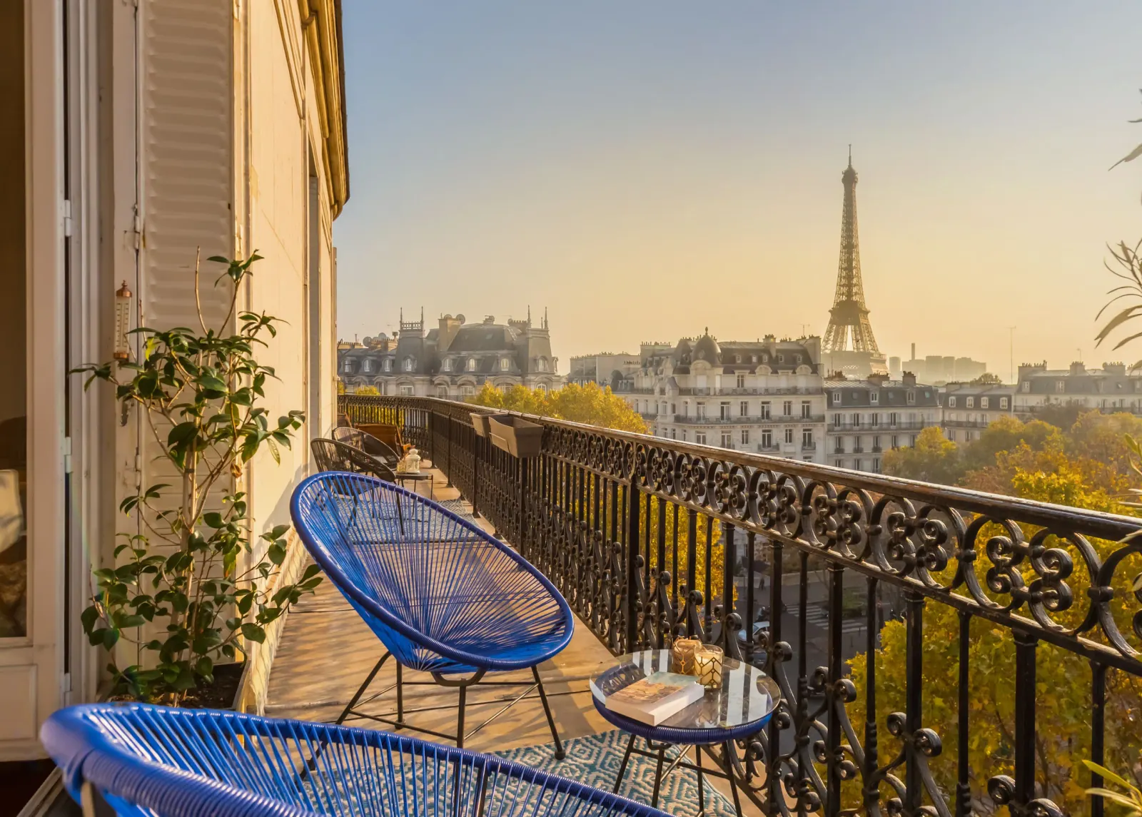 A varanda de um apartamento parisiense e a Torre Eiffel ao fim do dia