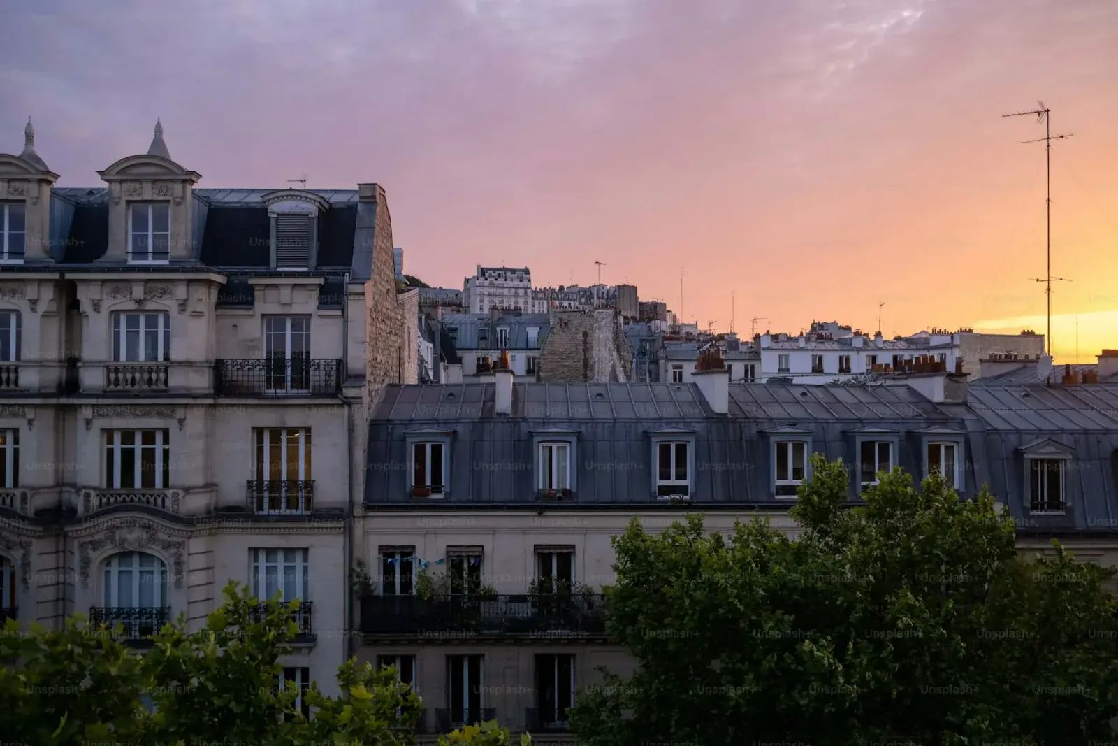 Les toits de zinc et les mansardes de Paris au coucher du soleil