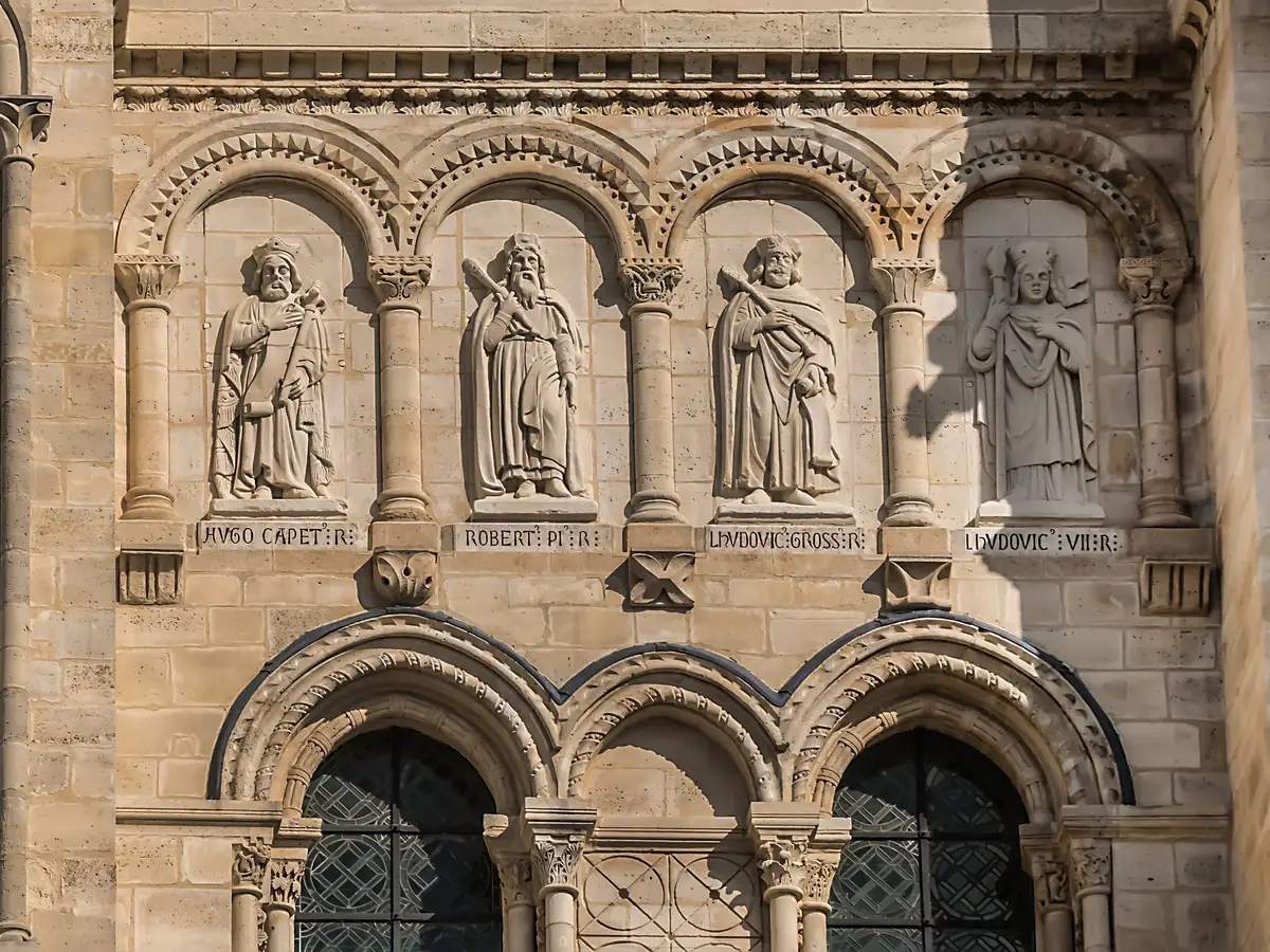 O portal da basílica catedral de Saint-Denis, os seus arcos românicos e as estátuas dos reis de França acima das portas