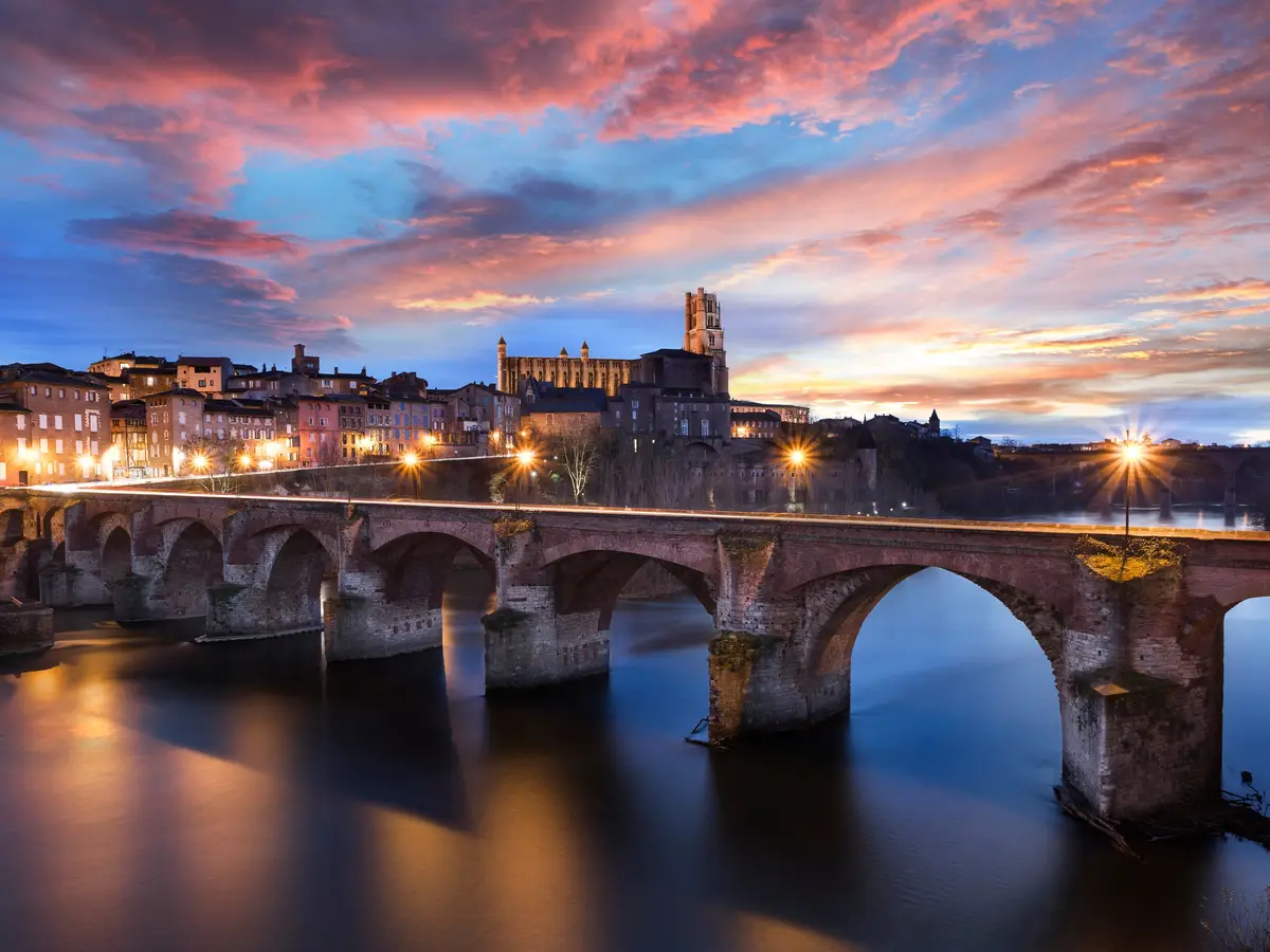 Le Pont-Vieux sur le Tarn et la cathédrale Sainte-Cécile d’Albi au coucher du soleil, sous un ciel rose et bleu