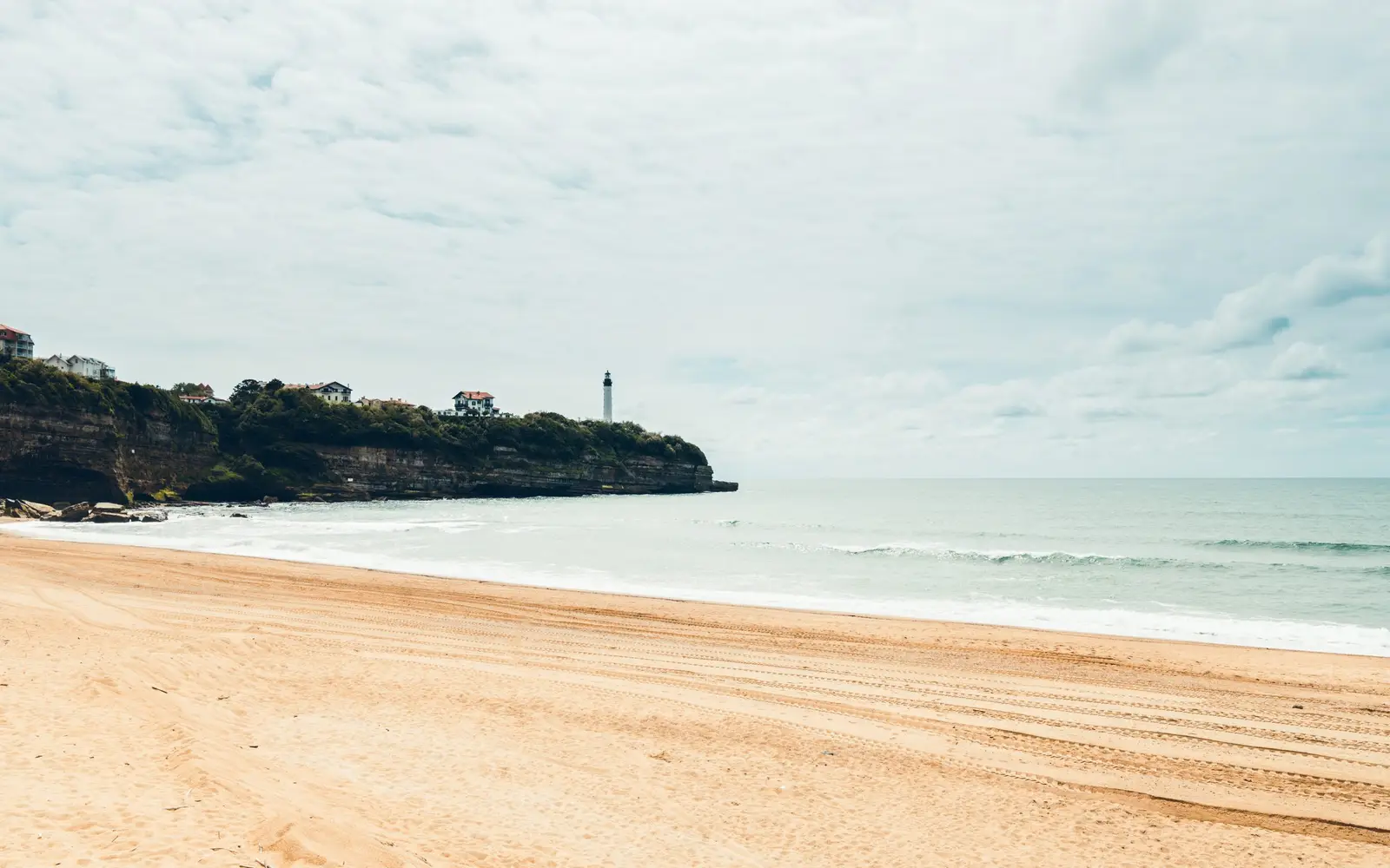 La plage d’Anglet et la falaise de la Chambre d’Amour, ses villas et le phare de Biarritz au bout