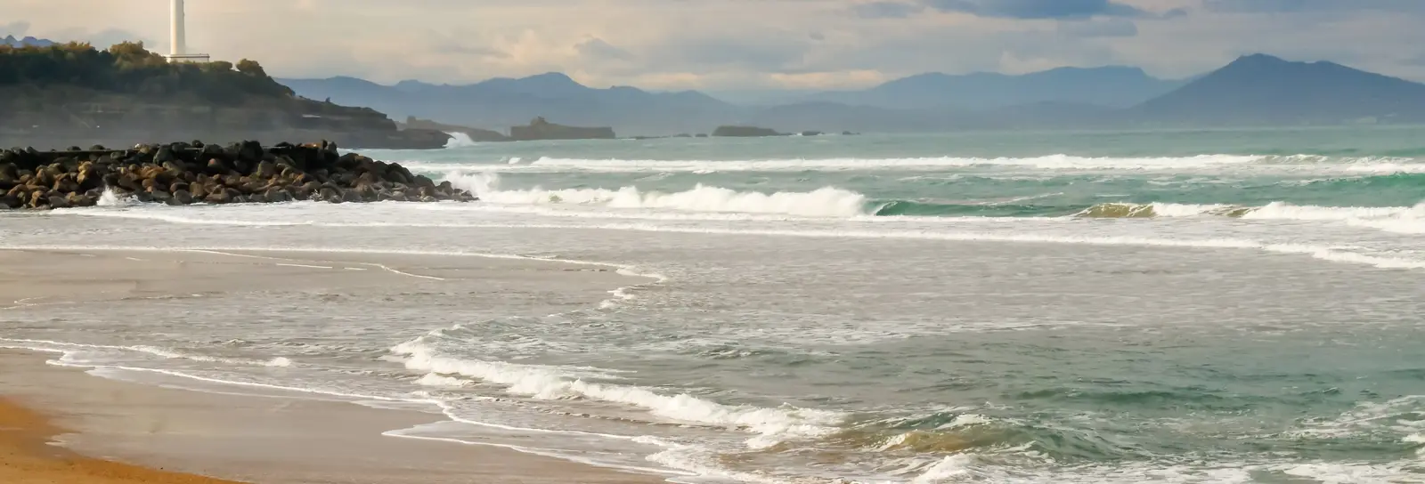 Une plage d’Anglet à marée basse, les vagues de l’Atlantique et la côte basque jusqu’aux montagnes