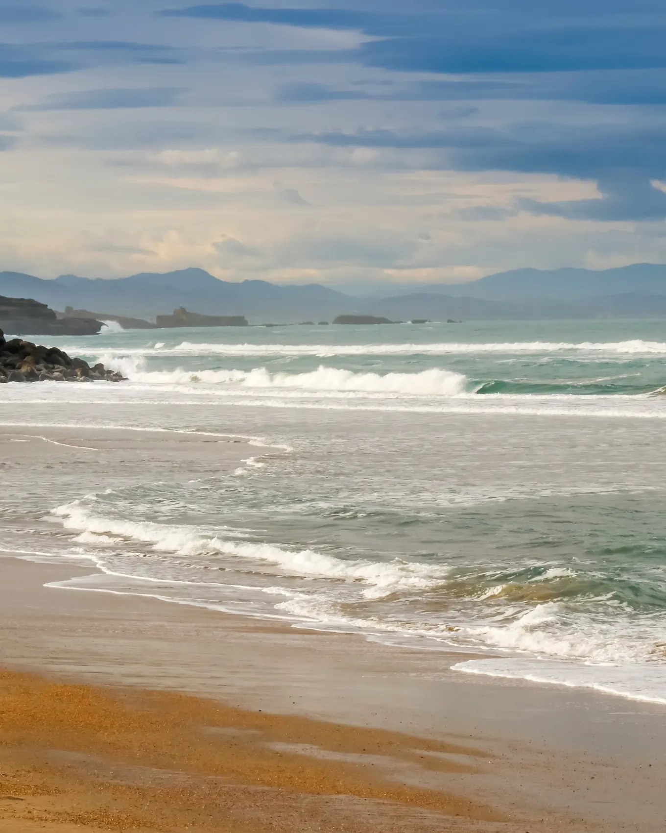 Une plage d’Anglet à marée basse, les vagues de l’Atlantique et la côte basque jusqu’aux montagnes