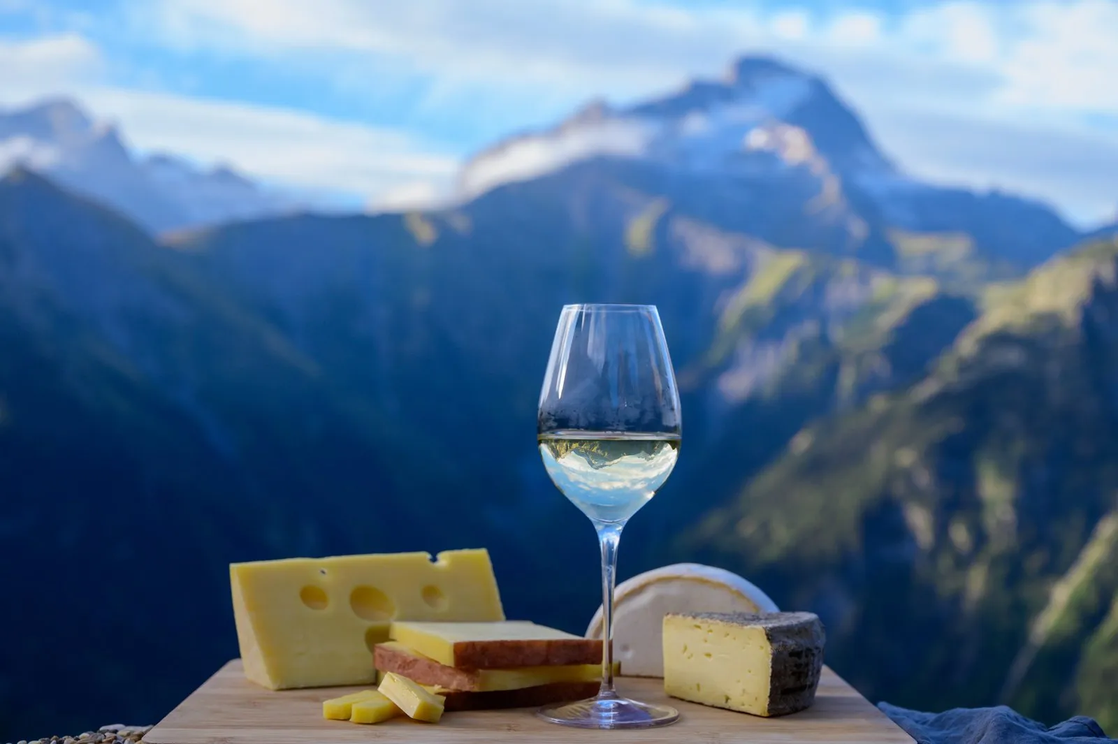 Queijos da Saboia e vinho branco diante das montanhas da região de Annecy