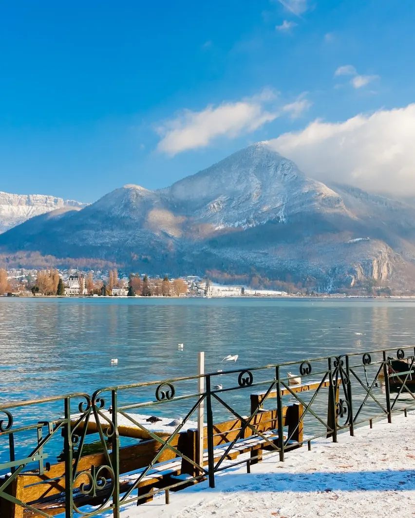 Le quai enneigé du lac d'Annecy et les sommets en hiver