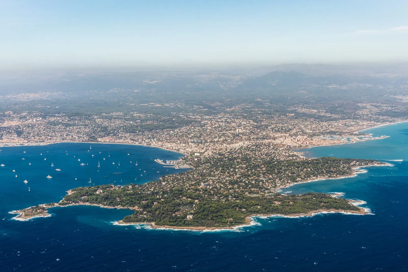 O Cap d’Antibes, os seus pinheiros-mansos e as moradias sob as palmeiras