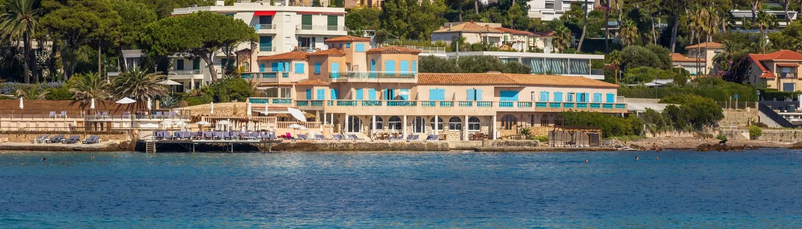 A waterfront hotel beneath the umbrella pines