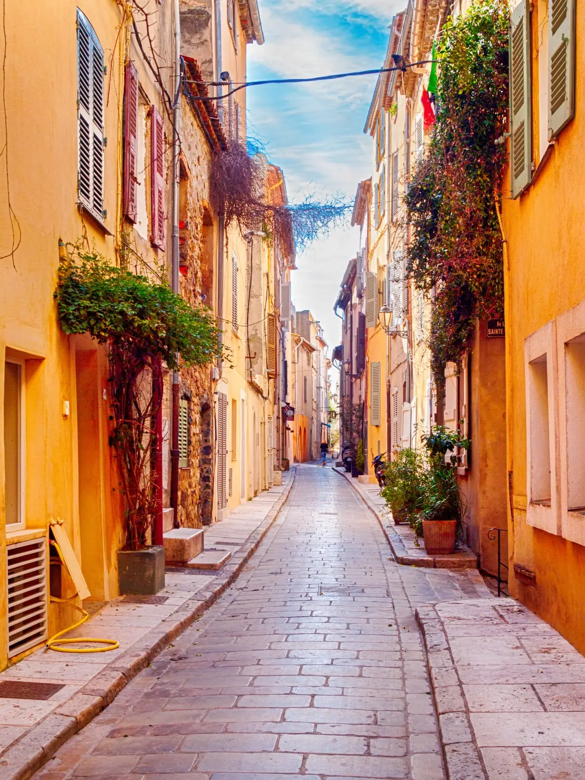 Une ruelle aux façades ocre et pastel de la vieille ville