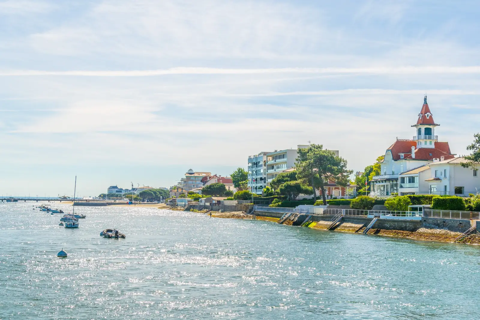 A frente de mar de Arcachon vista da baía, uma villa com torreão, os pinheiros e os edifícios da praia