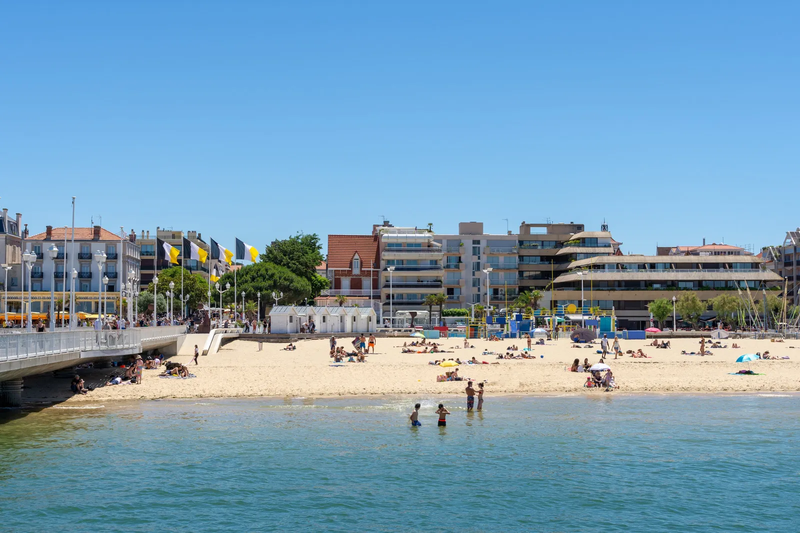 La plage d’Arcachon et la jetée Thiers, les immeubles et les drapeaux du front de mer en plein été