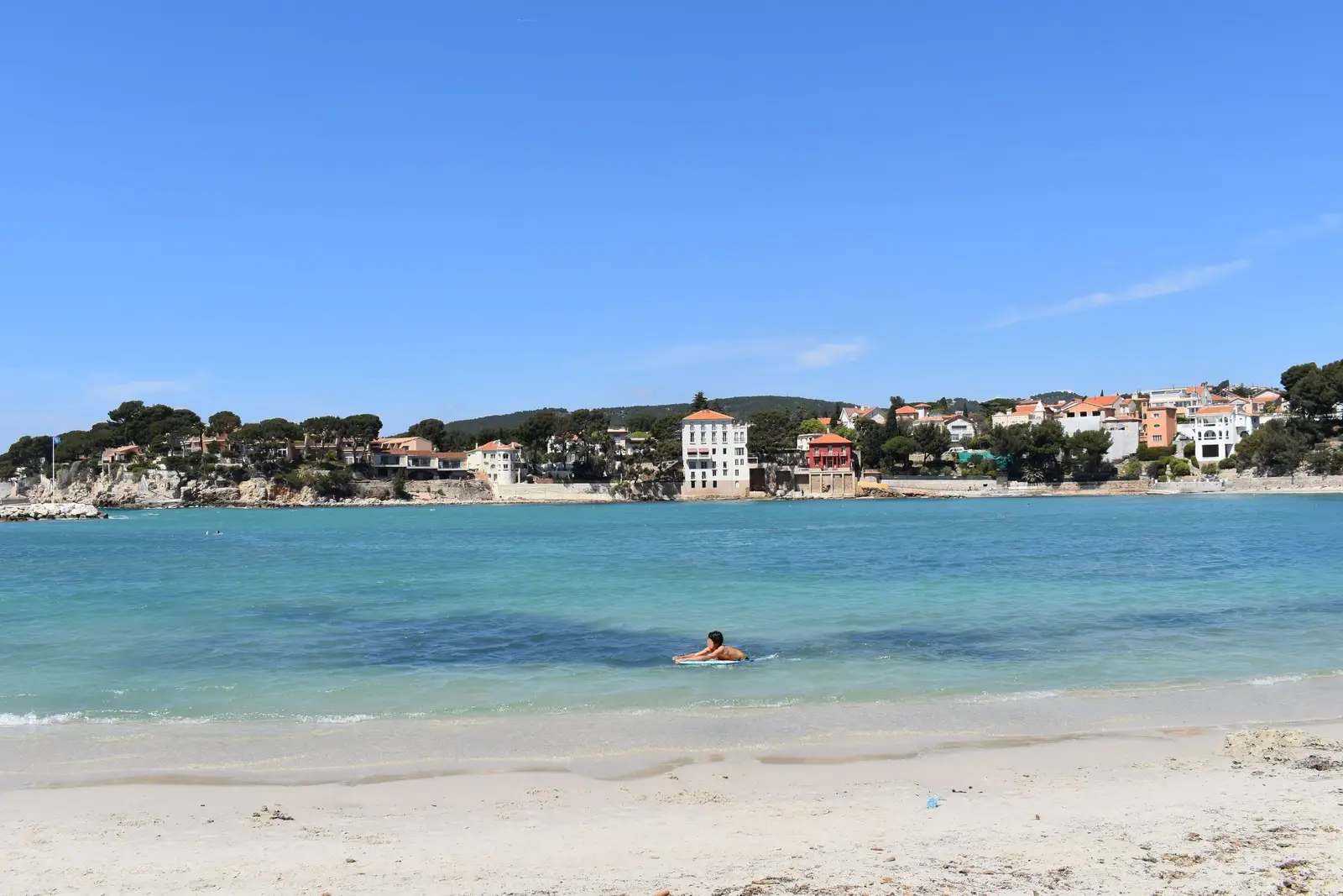 L’anse de Renécros à Bandol, sa plage de sable, l’eau turquoise et les villas sous les pins de la pointe