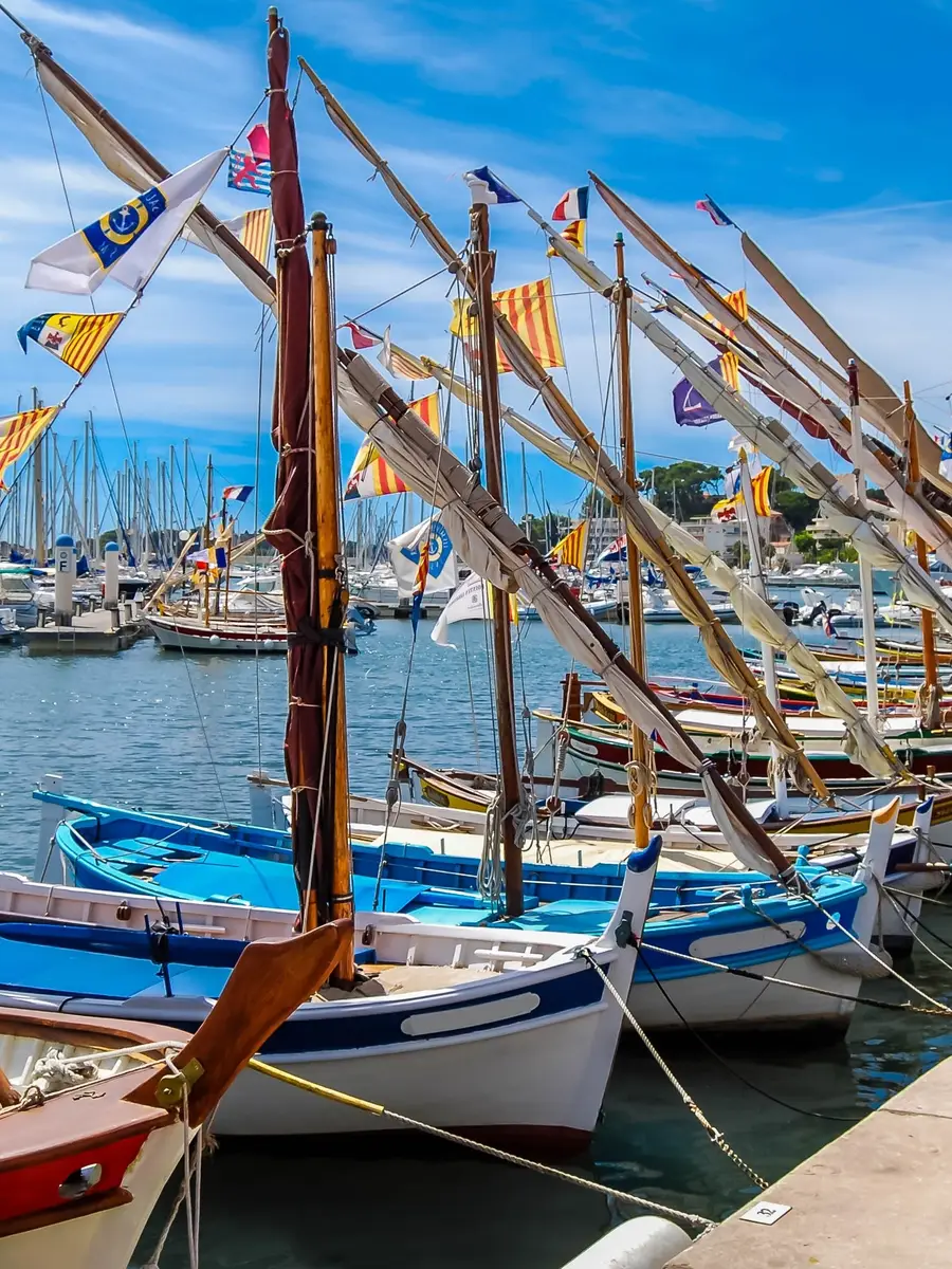 Les pointus pavoisés à quai sur le port de Bandol, leurs mâts et leurs fanions sous le ciel bleu