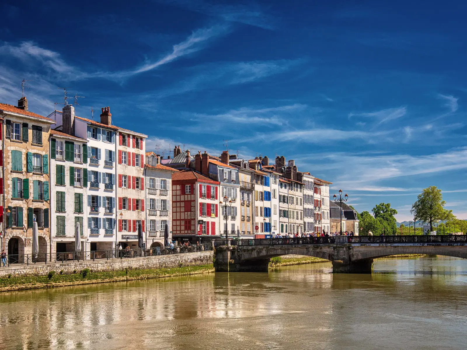 As fachadas coloridas dos cais do Nive em Bayonne, as suas portadas vermelhas e verdes e a ponte sobre o rio