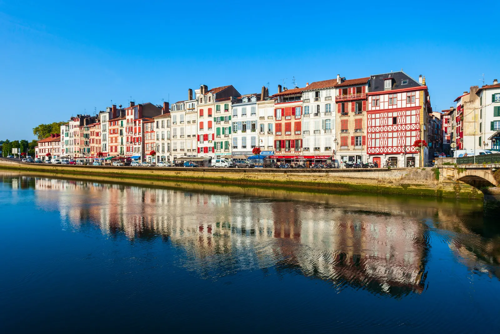 The colourful façades of the Bayonne quays reflected in the river