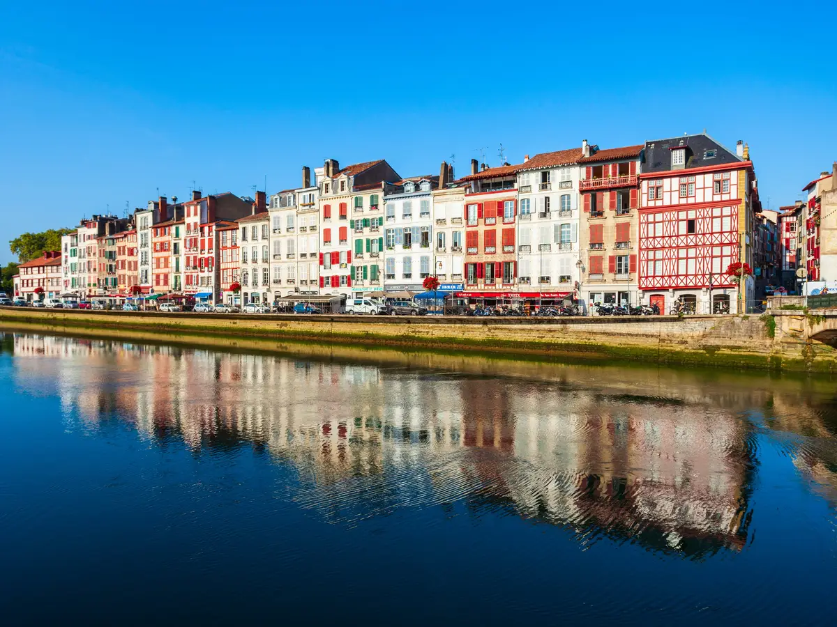 As fachadas coloridas dos cais de Bayonne refletidas no rio