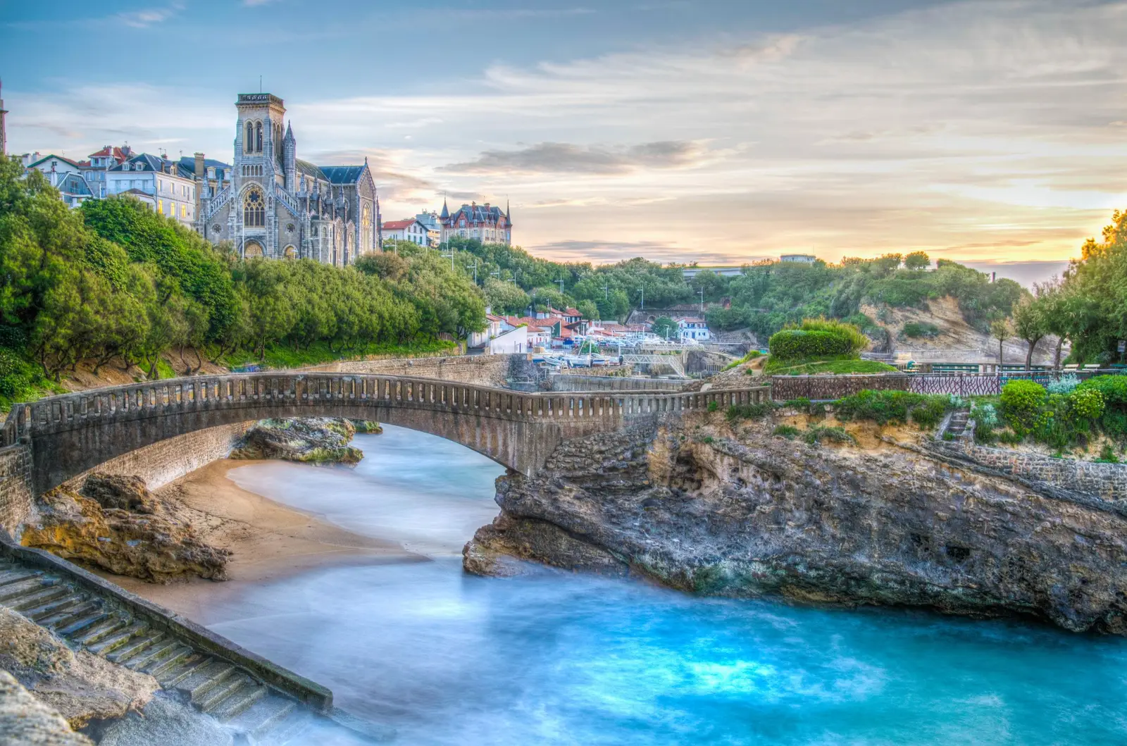Le pont du Rocher du Basta à Biarritz, l’église Sainte-Eugénie et les villas du port des Pêcheurs au-dessus de l’eau turquoise