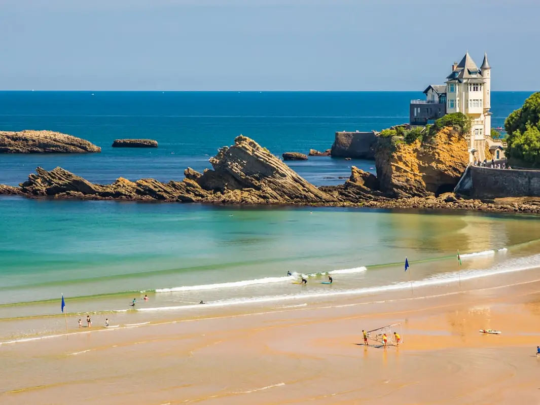 Une plage au pied des rochers, la villa Belza sur son promontoire