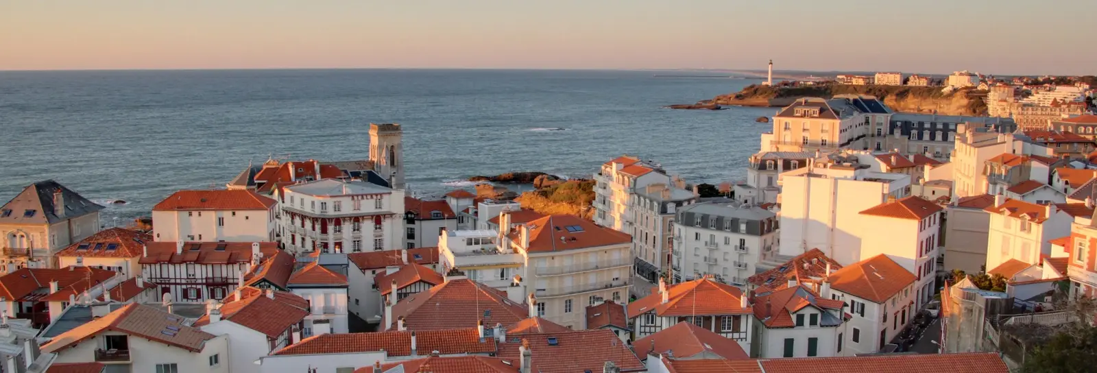 Os telhados de Biarritz ao pôr do sol, o oceano e o farol ao longe