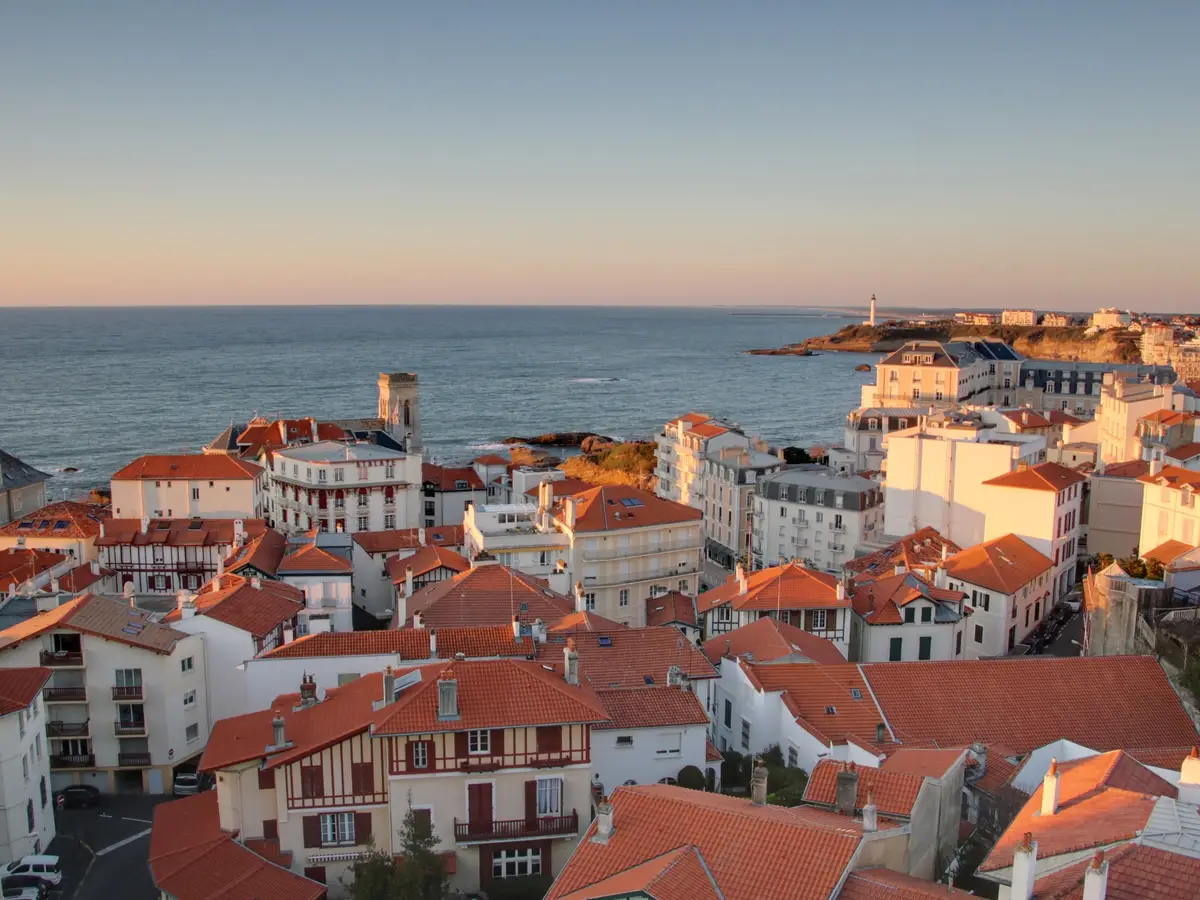 The rooftops of Biarritz at sunset, the ocean and the lighthouse in the distance