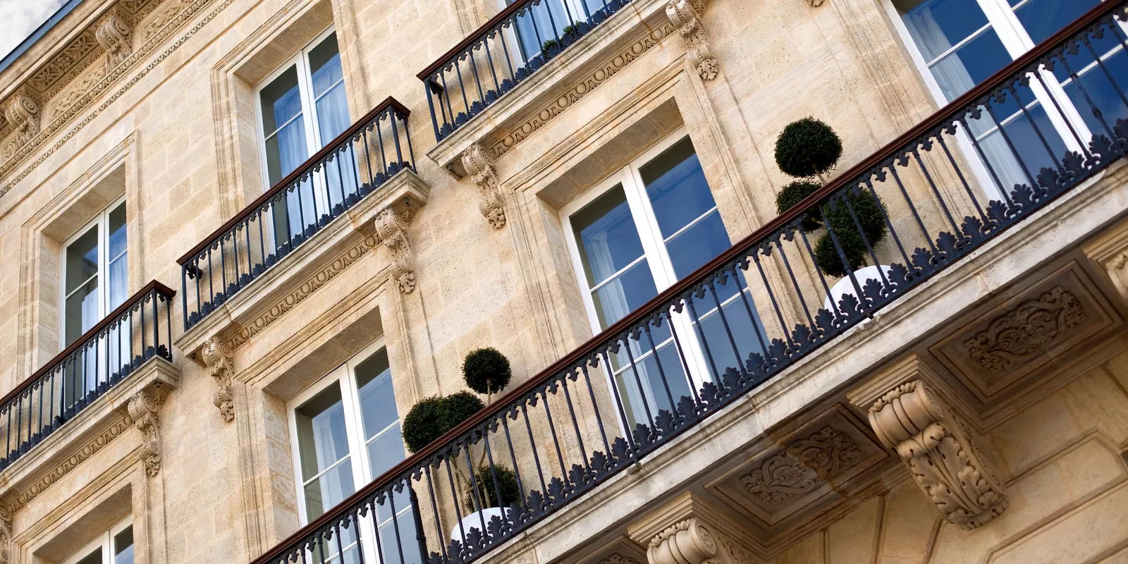 Les balcons en fer forgé d’une façade bordelaise, vus d’en bas