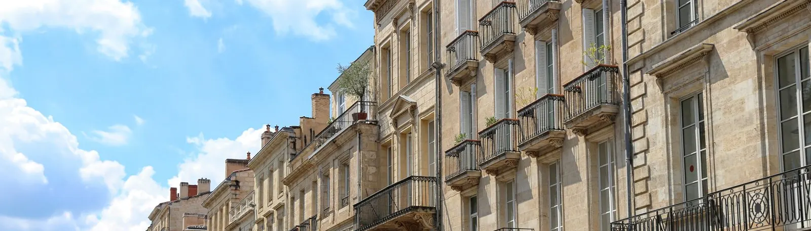 L’alignement des façades de pierre et des balcons en fer forgé, à Bordeaux