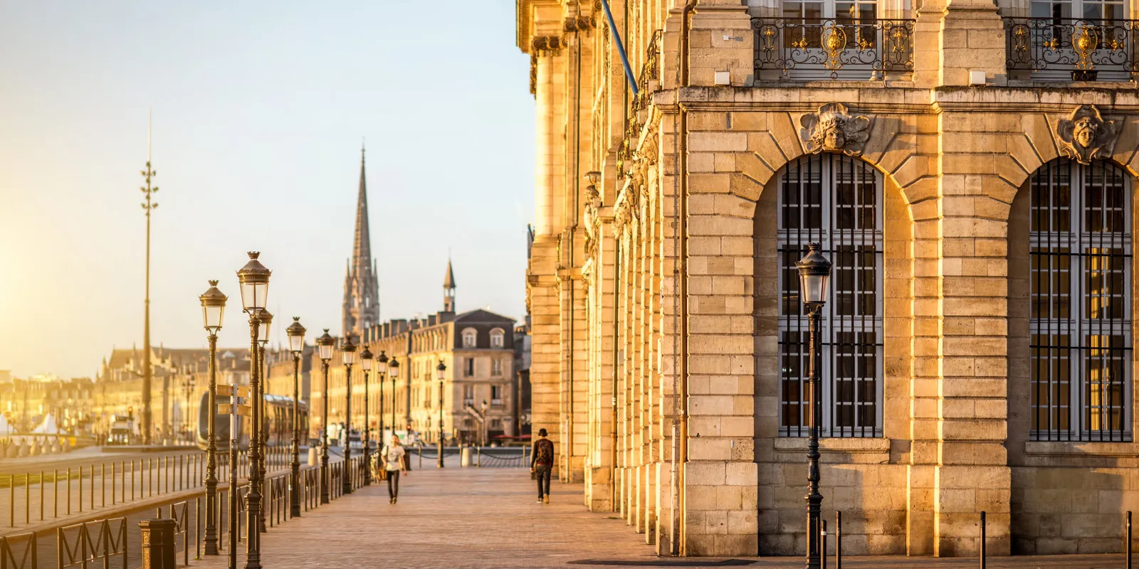 Les quais de la Garonne à Bordeaux au couchant, le long du palais de la Bourse, la flèche de Saint-Michel au loin