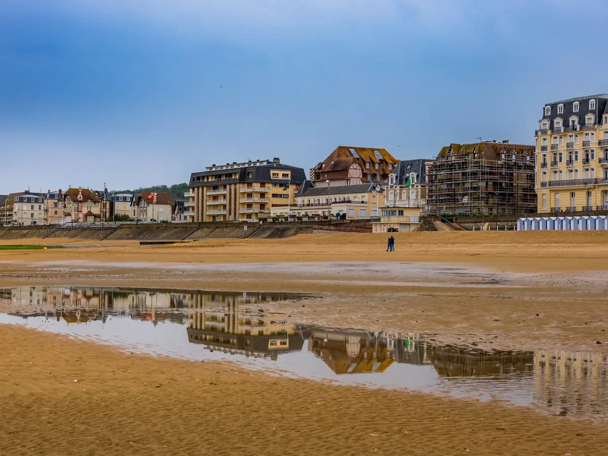 La plage de Cabourg à marée basse, le Grand Hôtel et les villas du front de mer reflétés dans le sable mouillé