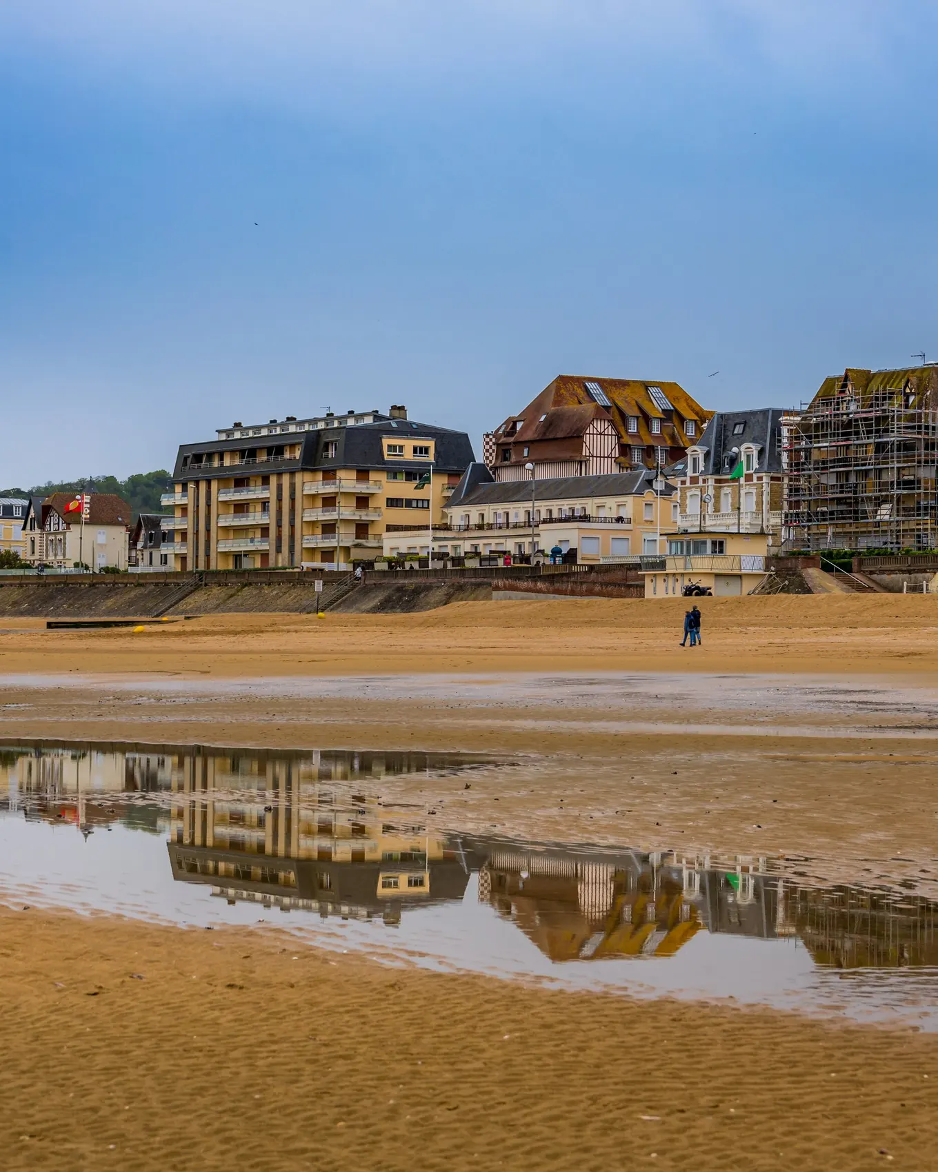 La plage de Cabourg à marée basse, le Grand Hôtel et les villas du front de mer reflétés dans le sable mouillé