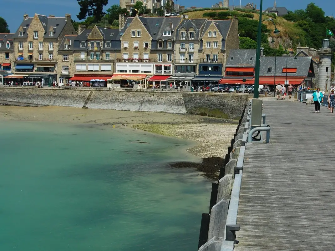 The Cancale jetty above the turquoise water and the houses of the port de la Houle
