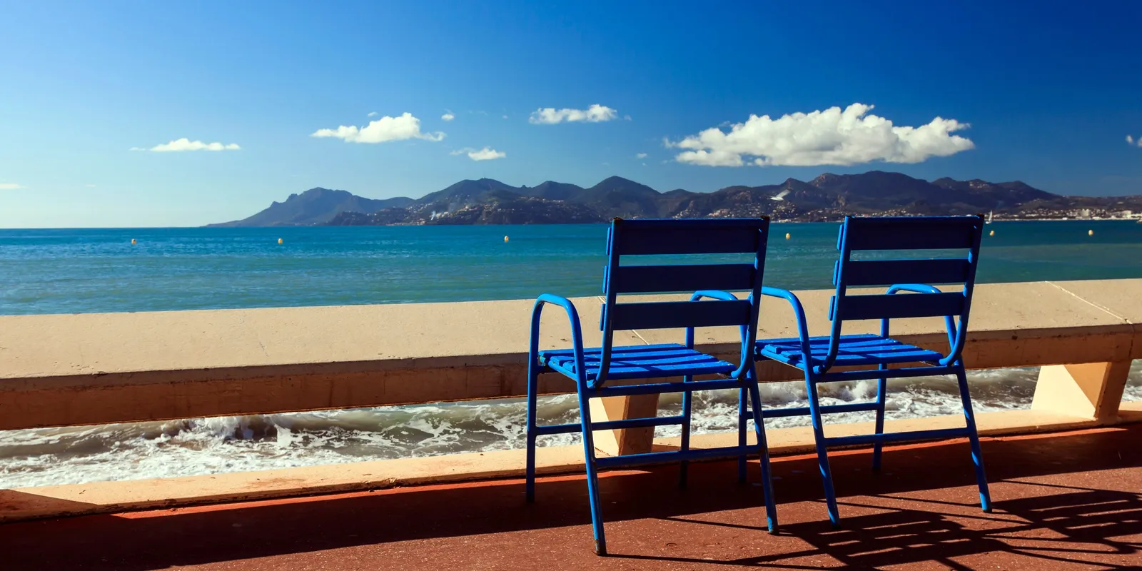 The blue chairs of La Croisette facing the bay of Cannes and the Estérel