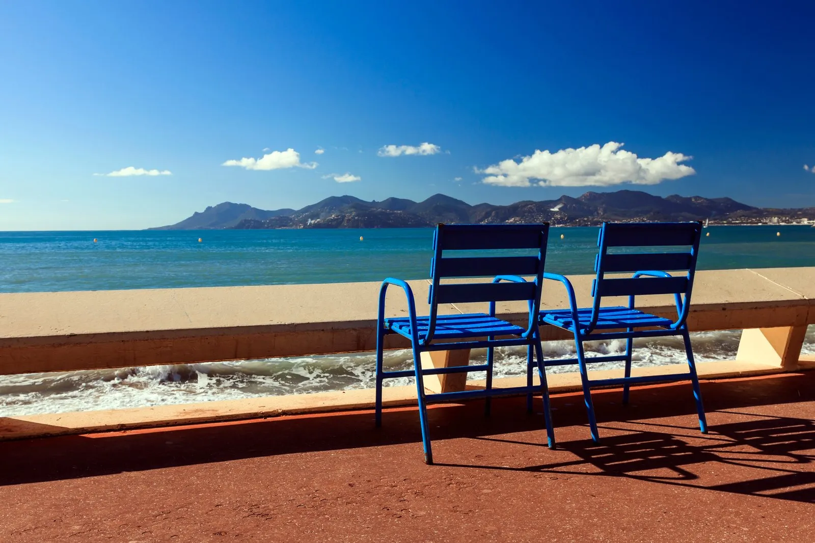 Les chaises bleues de la Croisette face à la baie de Cannes et à l’Estérel