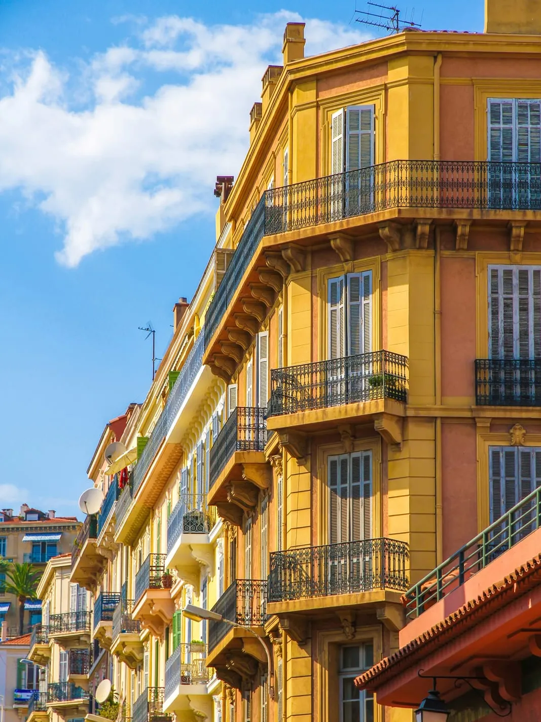 A yellow Belle Époque building and its wrought-iron balconies