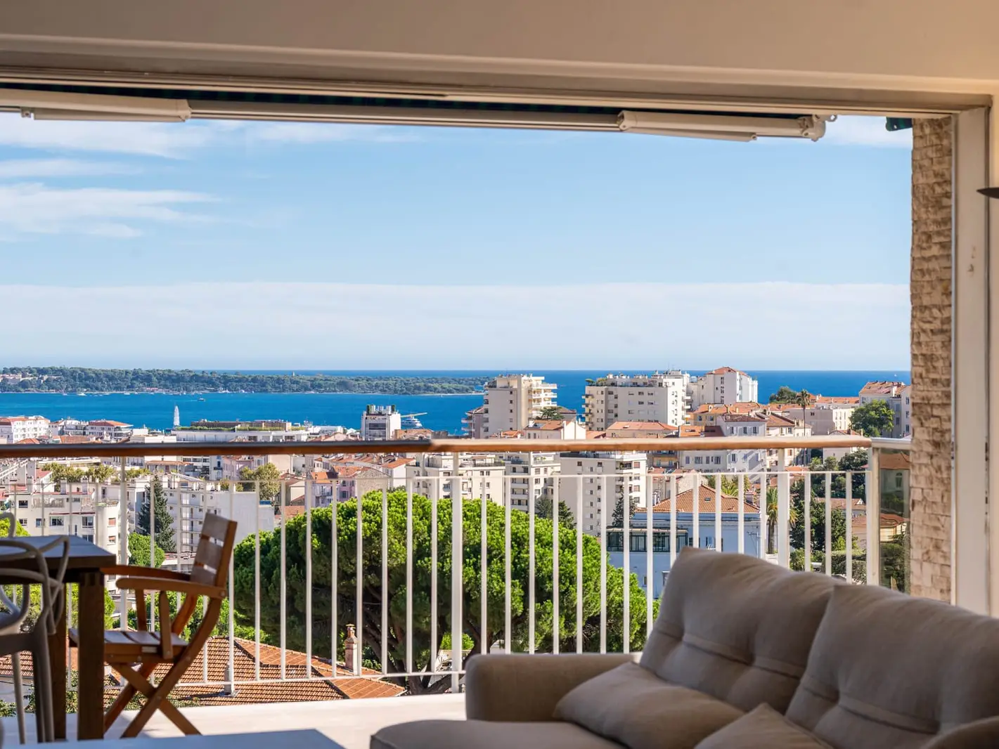 Uma sala aberta para a varanda, a baía e as ilhas de Lérins ao longe