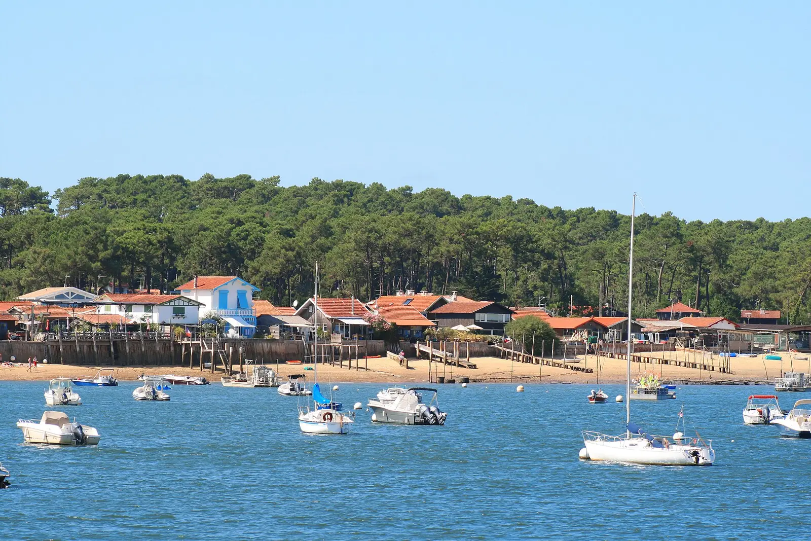 Casa de madeira no Cap Ferret pousada nas dunas, terraço e grandes envidraçados virados à erva das dunas
