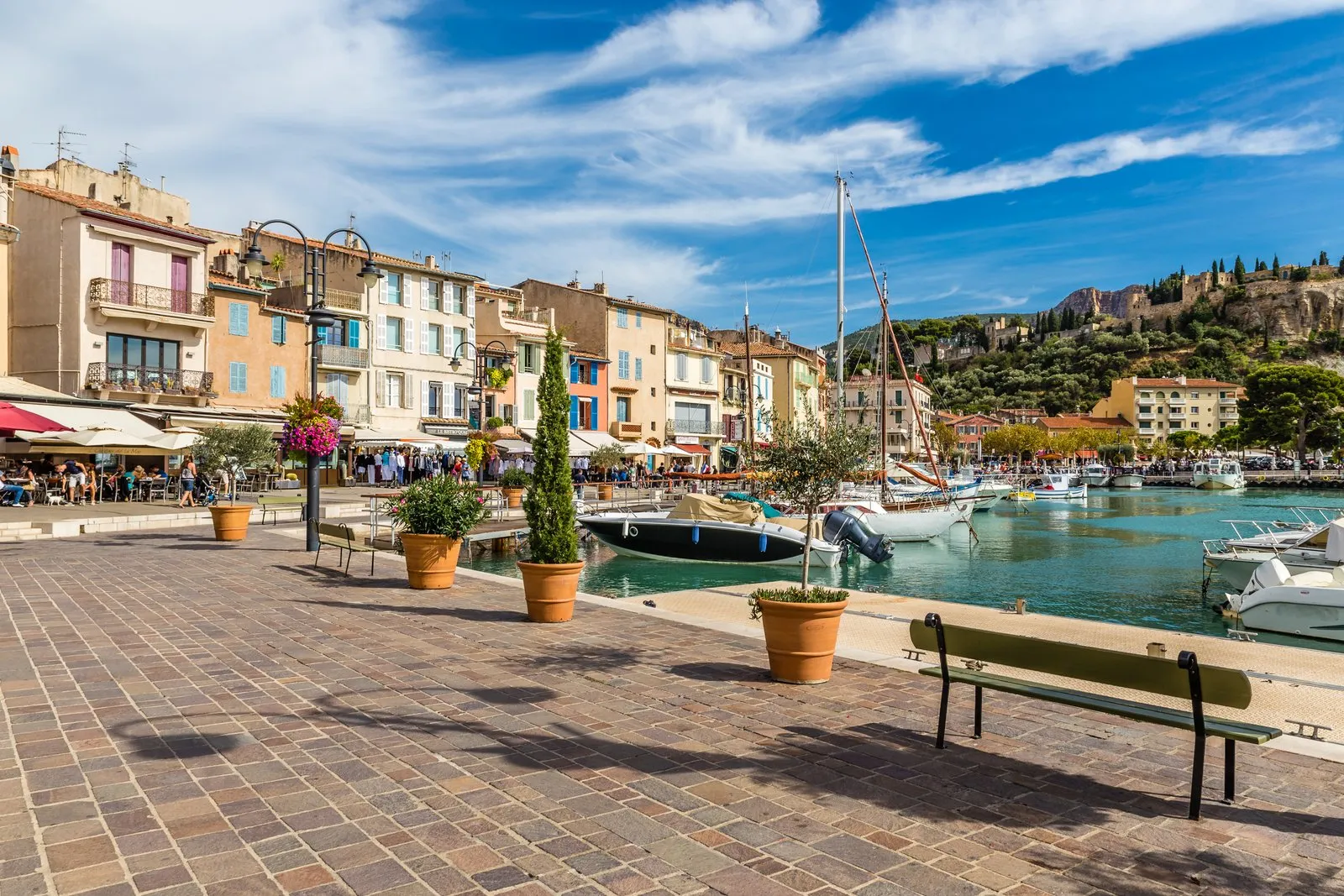 The quay of the port of Cassis, its terraces and the château on its hill