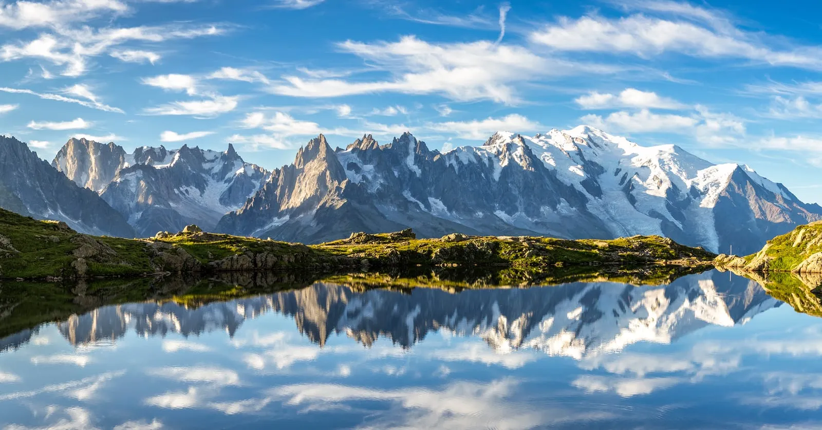 Les aiguilles du massif du Mont-Blanc reflétées dans un lac d’altitude