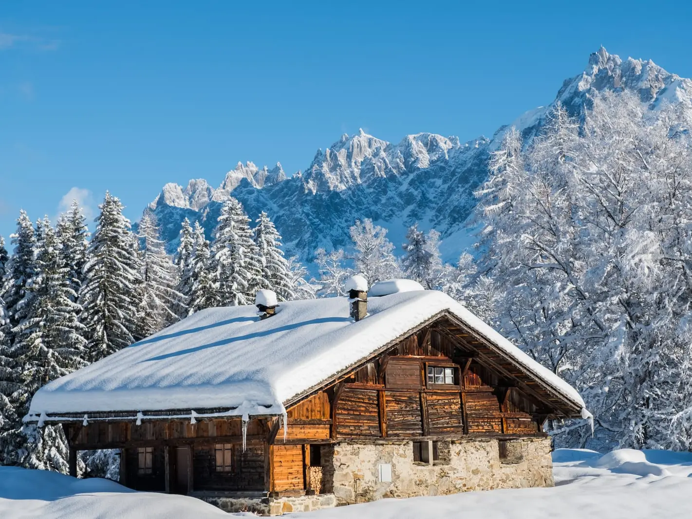 Um chalé de madeira sob a neve, entre os abetos