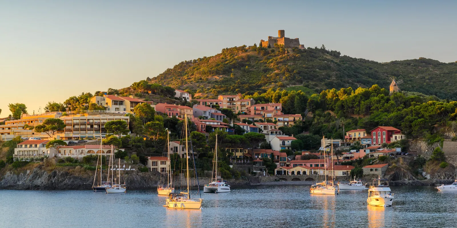 La baie de Collioure au petit matin, les voiliers au mouillage et le fort Saint-Elme sur la colline